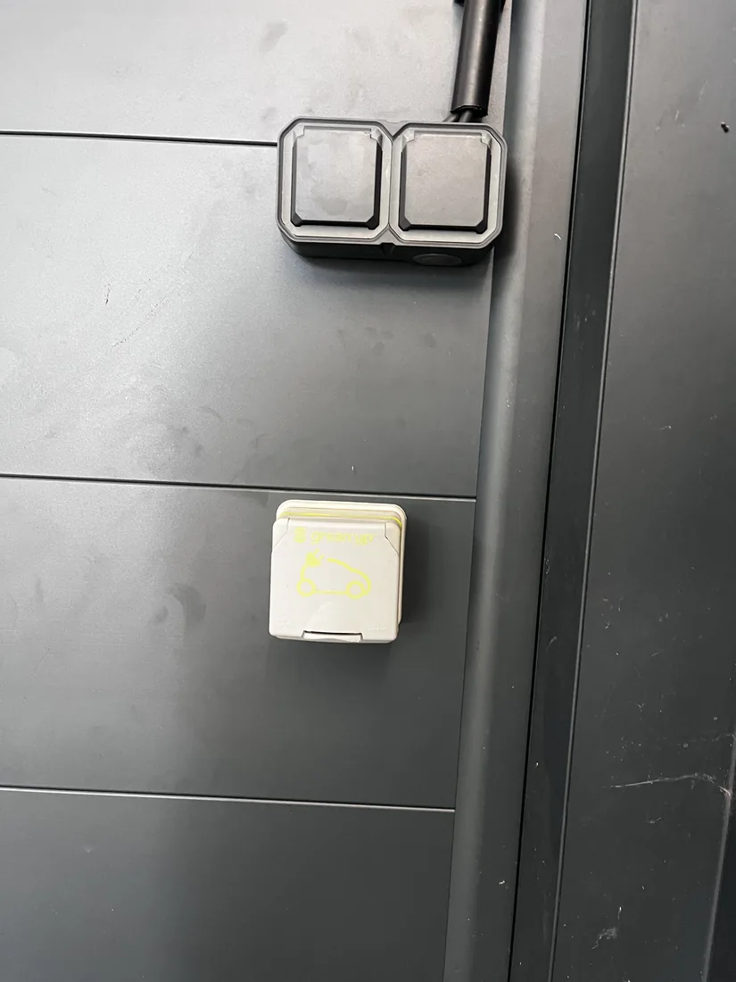 Prises étanches sur le bardage d'un carport, dont une prise renforcée pour la recharge d'un véhicule électrique.