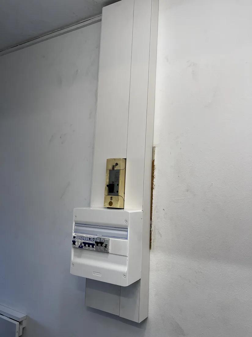 Nouveau tableau électrique fermé, alimenté par une goulotte verticale propre le long du mur.